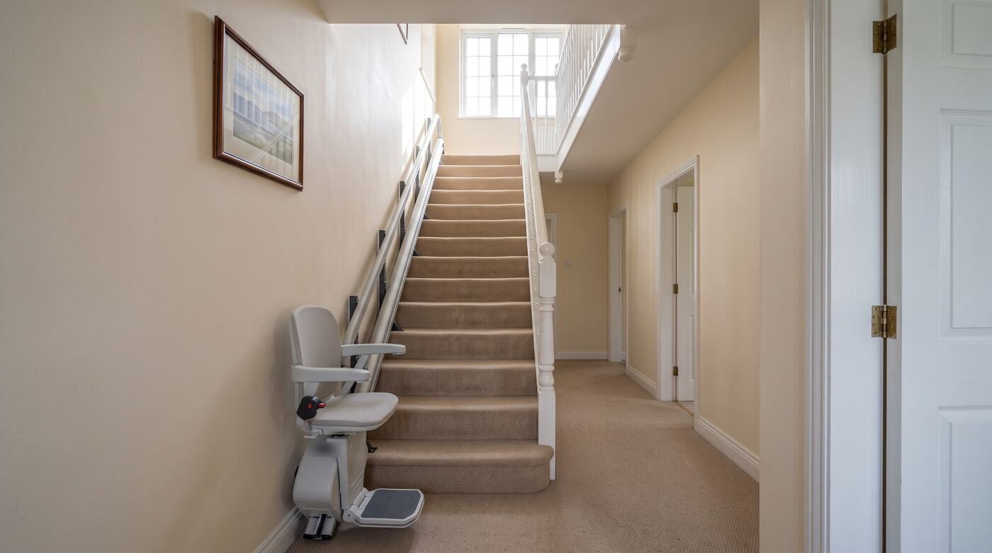 A stairlift fitted to a carpeted staircase in an Irish home